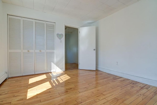 unfurnished bedroom with light wood-style floors and a closet