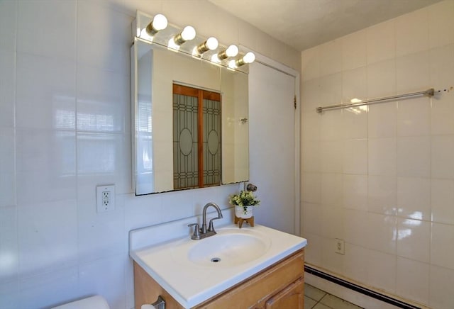 bathroom featuring tile walls, baseboard heating, and vanity