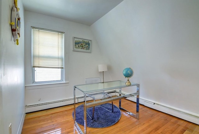 office space with wood finished floors, a baseboard heating unit, and baseboards