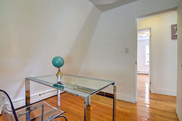office space featuring hardwood / wood-style floors, baseboard heating, and baseboards