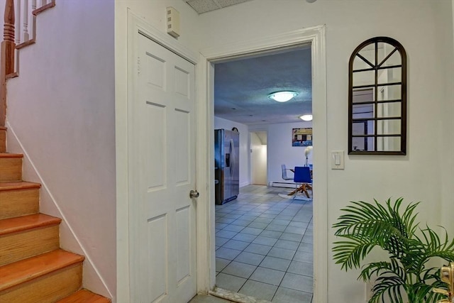 hall with stairway and light tile patterned flooring