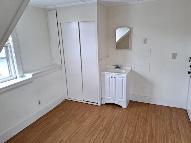 bathroom featuring wood-type flooring, vanity, and tile walls