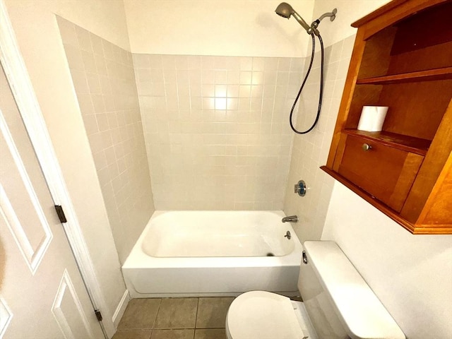 bathroom with tile patterned flooring, tiled shower / bath, and toilet