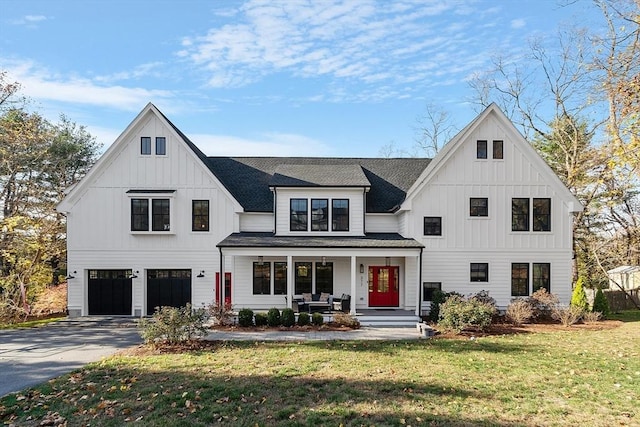 modern inspired farmhouse featuring a garage, a porch, and a front lawn