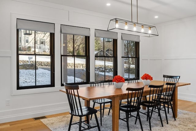 dining room with wood-type flooring and plenty of natural light