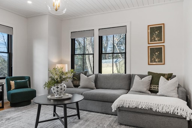 living room with ornamental molding, a notable chandelier, wood ceiling, and hardwood / wood-style floors