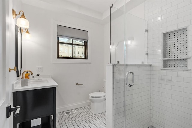 bathroom with toilet, a shower with door, and vanity