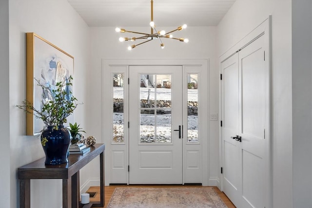 entryway with a notable chandelier and light hardwood / wood-style flooring