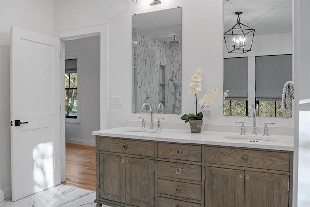 bathroom featuring a shower, vanity, and an inviting chandelier