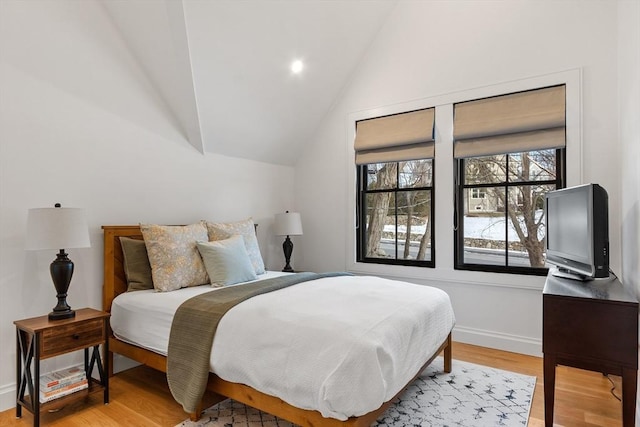 bedroom with vaulted ceiling and light hardwood / wood-style flooring