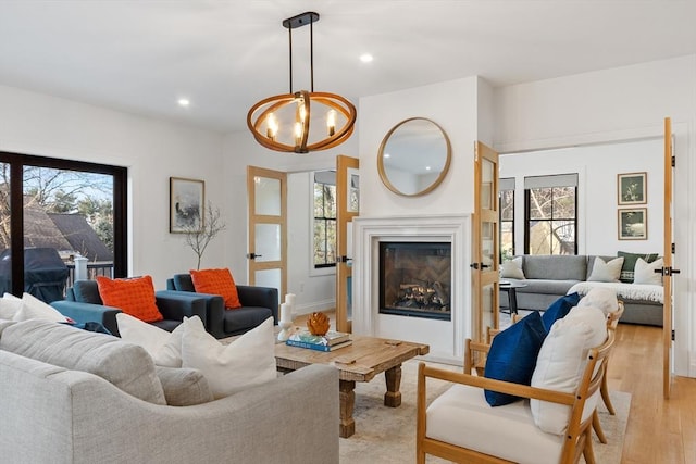 living room featuring a chandelier and light wood-type flooring