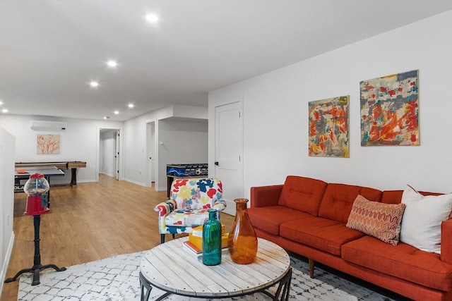 living room with light wood-type flooring and an AC wall unit