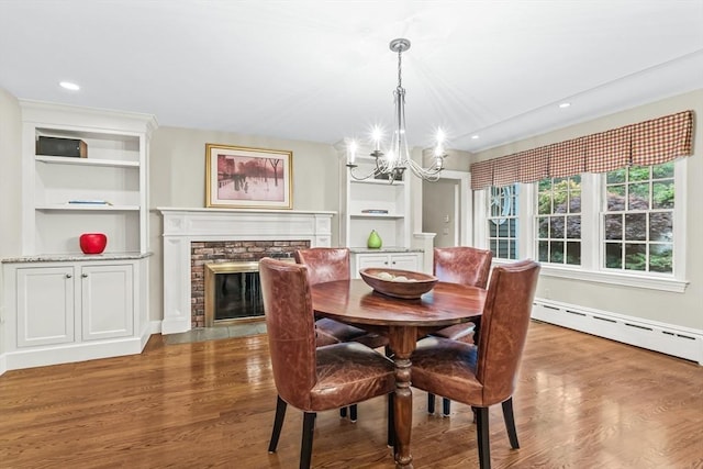 21 Fernway, Winchester, MA 01890 - dining space featuring baseboard heating, a chandelier, wood finished floors, a fireplace, and recessed lighting
