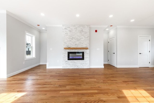 unfurnished living room featuring crown molding, a stone fireplace, and light wood finished floors