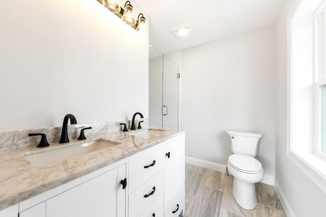 full bathroom with toilet, a shower with door, baseboards, and a sink