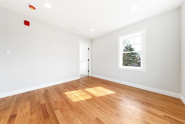 unfurnished room featuring light wood finished floors, baseboards, and recessed lighting