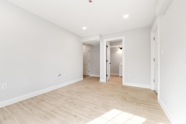 unfurnished bedroom featuring wood tiled floor, baseboards, and recessed lighting