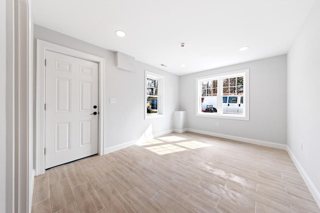 empty room featuring wood tiled floor, baseboards, and recessed lighting