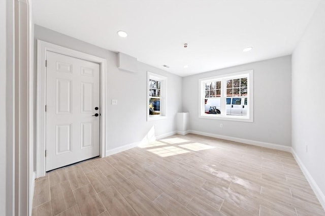 spare room with wood finish floors, baseboards, and recessed lighting