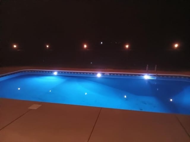 pool at twilight with a fenced in pool
