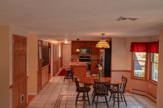 dining space featuring light tile patterned floors, baseboards, visible vents, and baseboard heating