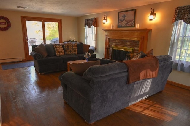living room with visible vents, a baseboard radiator, wood finished floors, and a wealth of natural light