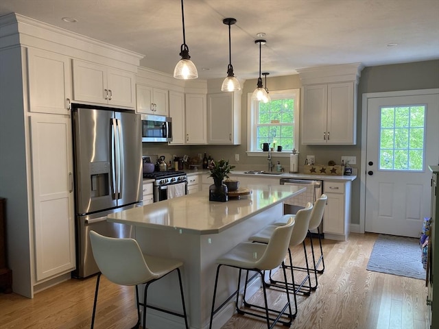 30 Old Washington St Unit 2, Pembroke, MA 02359 - kitchen featuring stainless steel appliances, a sink, a kitchen breakfast bar, light wood-style flooring, and recessed lighting