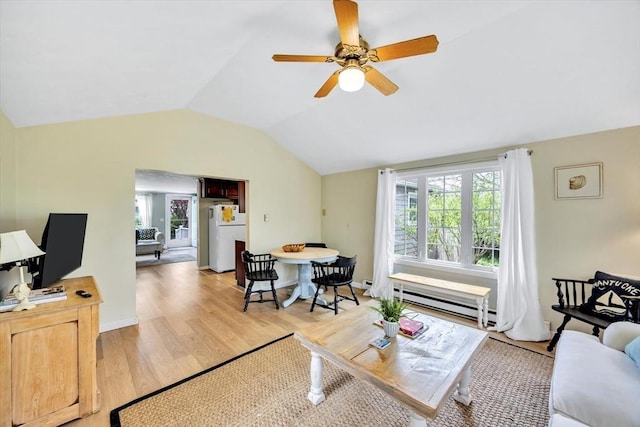 living room with baseboard heating, vaulted ceiling, light wood finished floors, and a ceiling fan