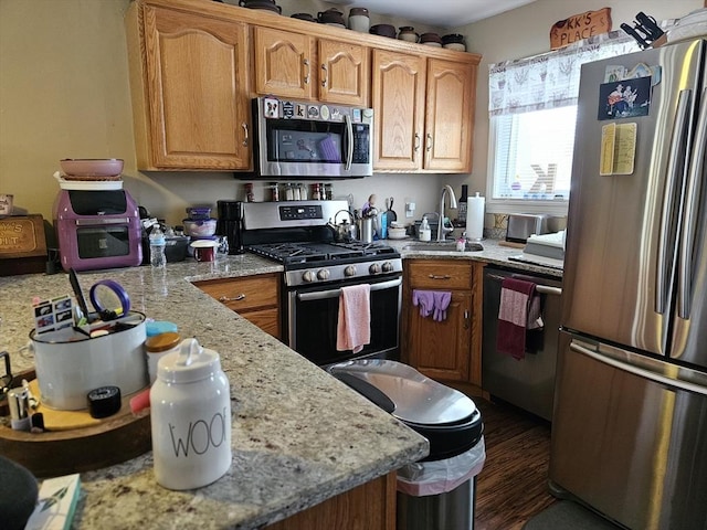 26 Harvard Unit C, Ayer, MA 01432 - kitchen featuring wood finished floors, appliances with stainless steel finishes, light stone countertops, and a sink