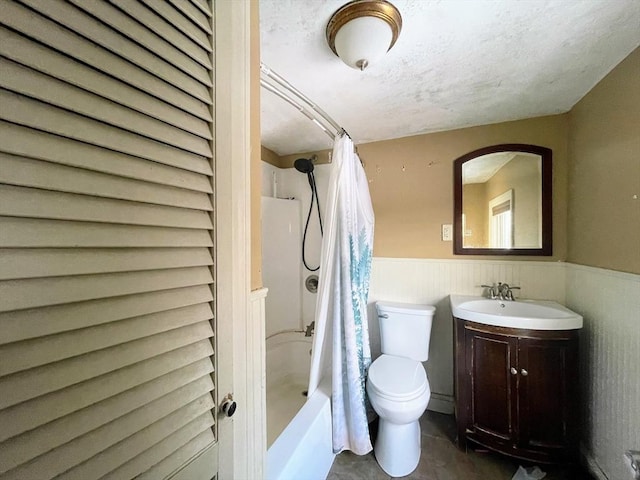 full bathroom with a textured ceiling, vanity, wooden walls, toilet, and shower / tub combo with curtain