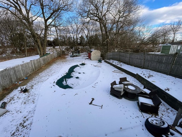 yard covered in snow with a storage unit