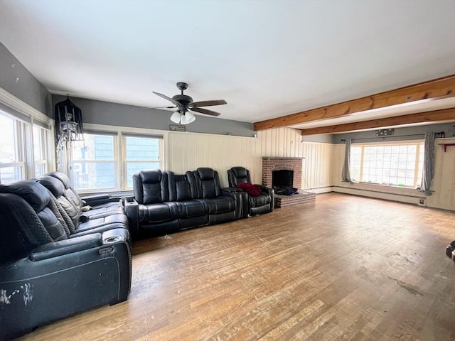 living room with ceiling fan, a healthy amount of sunlight, a fireplace, and a baseboard radiator