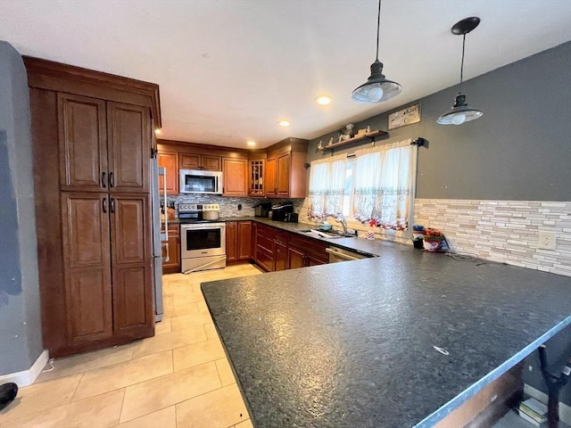 kitchen featuring pendant lighting, kitchen peninsula, decorative backsplash, stainless steel appliances, and light tile patterned floors