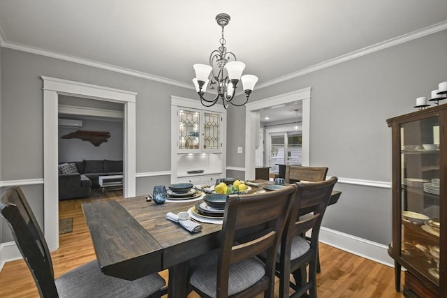 dining space with visible vents, crown molding, light wood finished floors, baseboards, and a chandelier