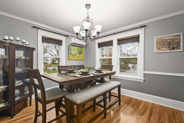 dining space featuring ornamental molding, a wall mounted AC, light wood-style floors, baseboards, and a chandelier