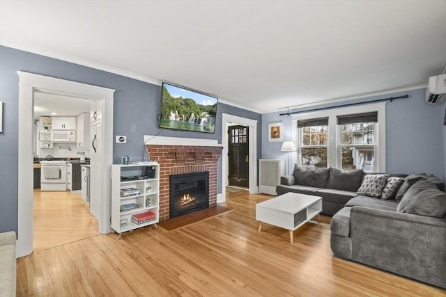 living area featuring light wood-style floors, a brick fireplace, and ornamental molding