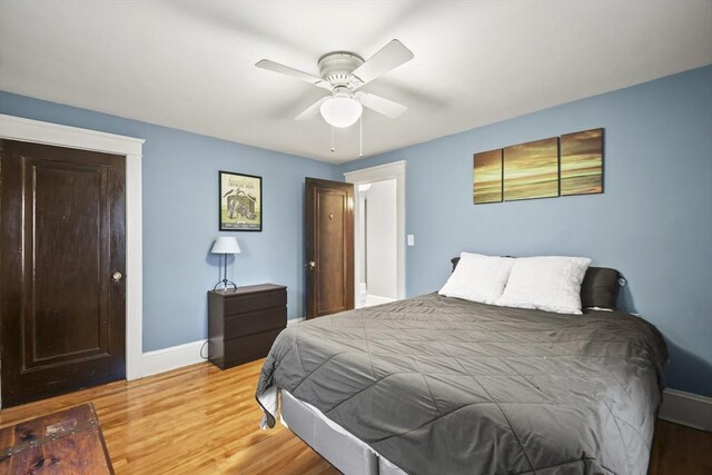 bedroom featuring baseboards, light wood-style floors, and a ceiling fan