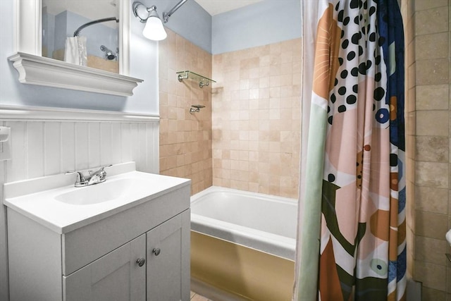 full bathroom with wainscoting, vanity, and shower / bath combo with shower curtain