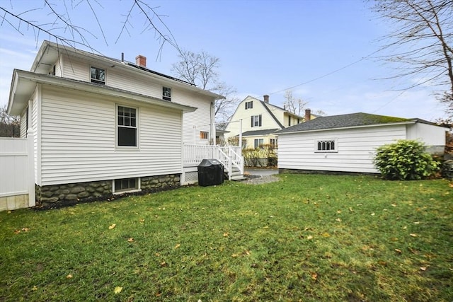 rear view of property with a wooden deck, a lawn, fence, and a chimney