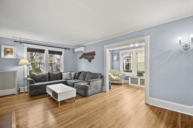 living area featuring light wood finished floors, a wealth of natural light, a wall unit AC, and ornamental molding