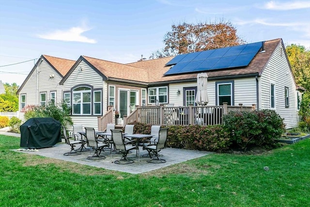 rear view of property with a patio area, solar panels, and a yard