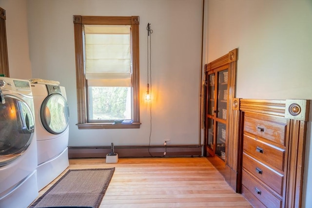 washroom featuring light wood-style floors, a baseboard radiator, laundry area, and washer and clothes dryer