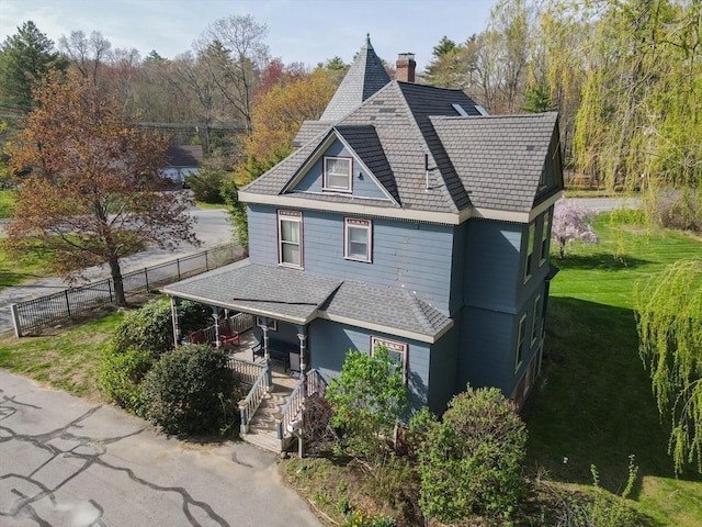 view of front facade with fence, a chimney, a porch, and a front yard