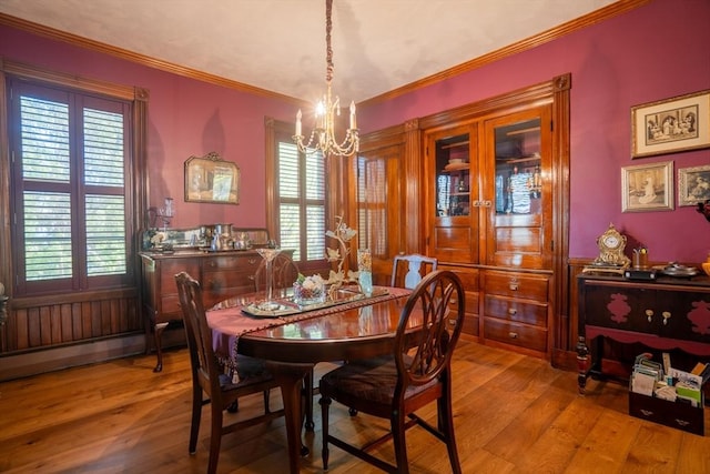dining space featuring an inviting chandelier, ornamental molding, wood-type flooring, and a wealth of natural light