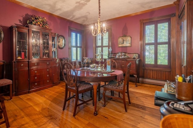 dining room featuring an inviting chandelier, light wood-type flooring, ornamental molding, and a baseboard radiator