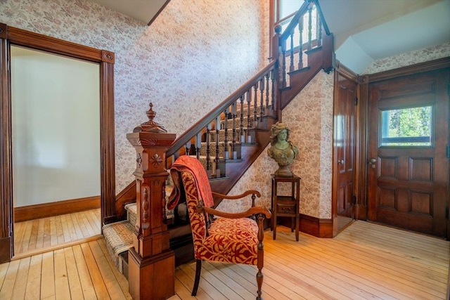 entryway featuring baseboards, stairs, hardwood / wood-style floors, and wallpapered walls