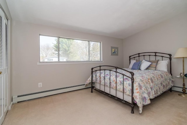 bedroom with a closet, carpet, and a baseboard heating unit