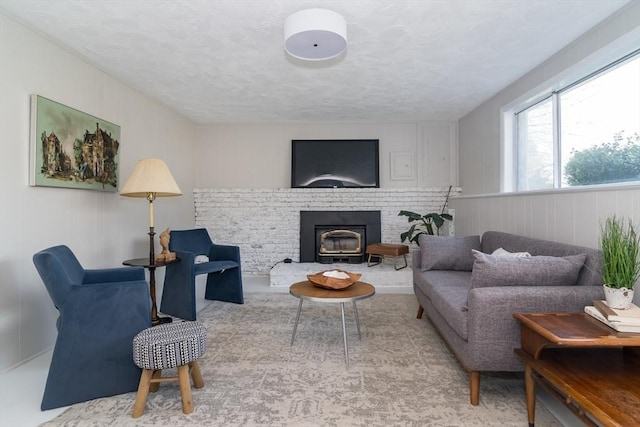 living room with a textured ceiling and a fireplace