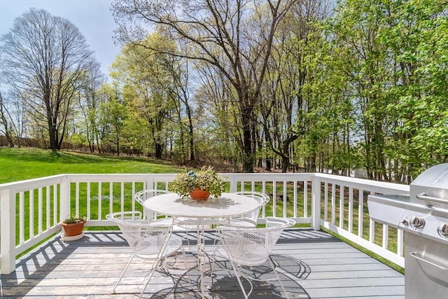 wooden terrace with a lawn and outdoor dining space