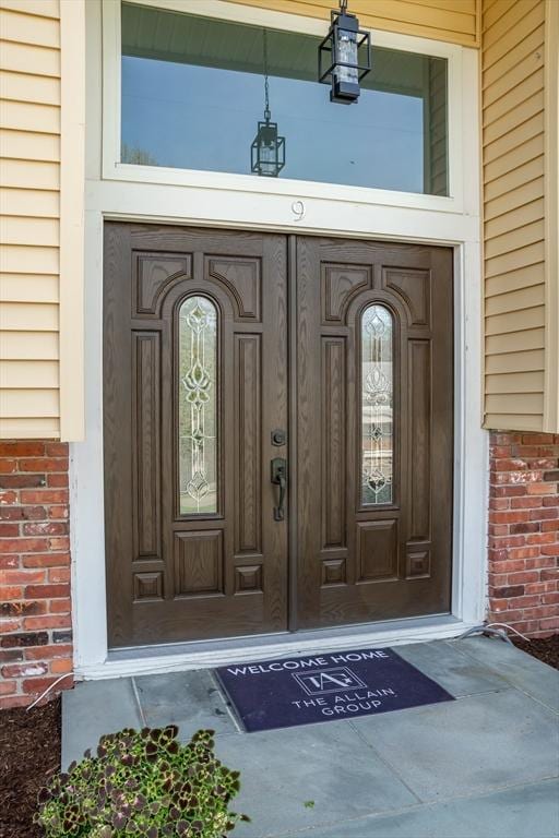 entrance to property featuring brick siding